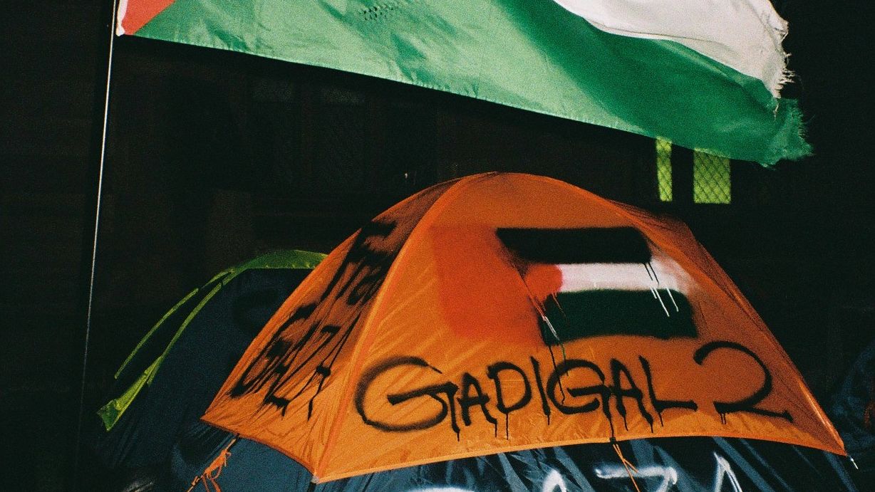 A tent graffitied with the Palestinian flag and the words "GADIGAL 2 GAZA" and "FREE GAZA"