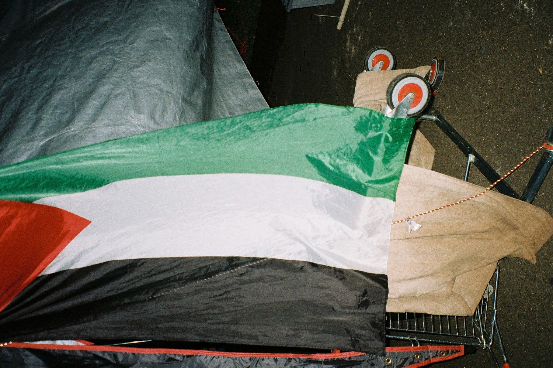 A Palestinian flag drapped over a tipped over trolley
