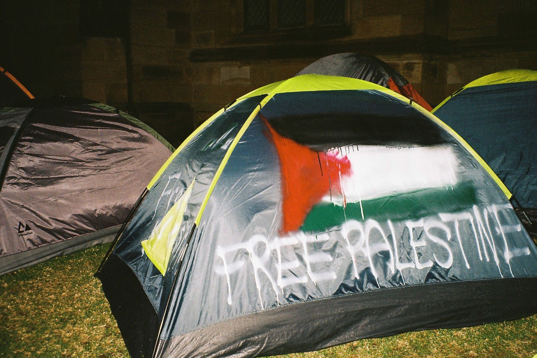 A tent with the words "FREE PALESTINE" and the Palestinian flag graffitied all over it